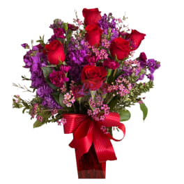 Bouquet of red roses and purple flowers with a red ribbon