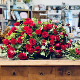 Large bouquet of red roses and carnations on a wooden table
