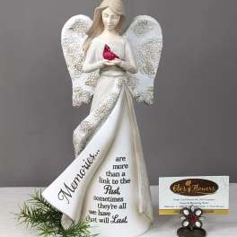 Decorative angel figurine holding a red bird with a memorial message on the dress