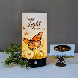 Butterfly memorial candle with daisies and the words 'Your Light remains'