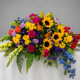 Colorful mixed flower arrangement with sunflowers, roses, and lilies on a table