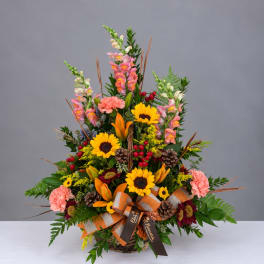Basket arrangement with sunflowers, lilies, carnations, and snapdragons