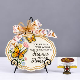Decorative memorial plaque with butterflies and flowers on a stand