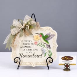 Decorative plaque with a hummingbird and flowers on a stand