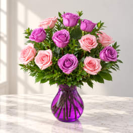 Pink and purple roses arranged in a purple glass vase