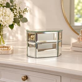 Mirrored glass tabletop box on a dresser beside a white floral arrangement