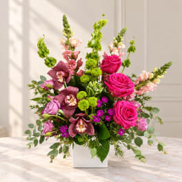 Pink roses and orchids in a white square vase