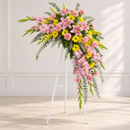 Pink and yellow floral spray on a white stand