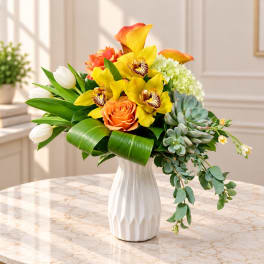 Bright mixed bouquet in a white vase with yellow orchids and orange roses