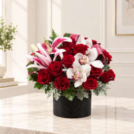 Red roses and pink-white lilies in a black box vase