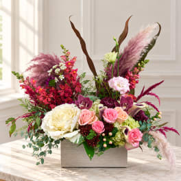 Mixed floral arrangement in a rectangular box with pink, white, and burgundy blooms