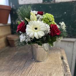Bouquet of red roses, white gerbera daisy, and green hydrangea in a metal bucket