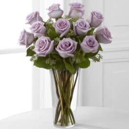 Lavender roses arranged in a clear glass vase
