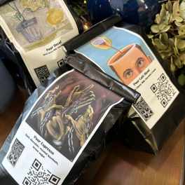 Three bags of packaged coffee beans with illustrated labels