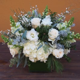 White roses and hydrangeas in a square vase with silver accents