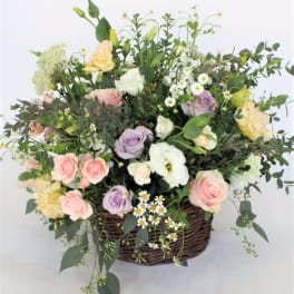 Mixed pastel roses and white blooms in a wicker basket