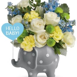 Bouquet in a gray polka-dot elephant container with a "Hello Baby!" sign