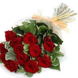 Bouquet of red roses wrapped in clear paper with a raffia bow