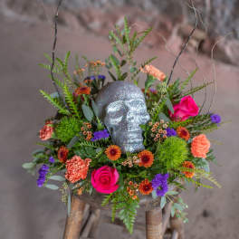 Floral arrangement with a glittery skull centerpiece on a stool