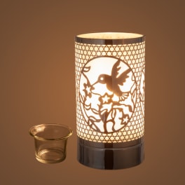 Lit decorative candle warmer with a small glass dish