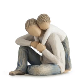 Wooden figurine of two seated people embracing