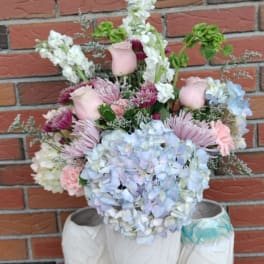 Pastel bouquet with hydrangeas, roses, and chrysanthemums in white vases