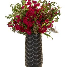 Magenta flower arrangement in a tall black vase