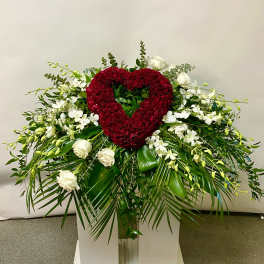 Heart-shaped red rose arrangement with white orchids and roses on a pedestal