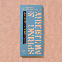Blue box of lavender rose date-sweetened chocolate on a pink fabric background
