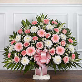 Pink and white floral arrangement in a vase with a pink ribbon bow