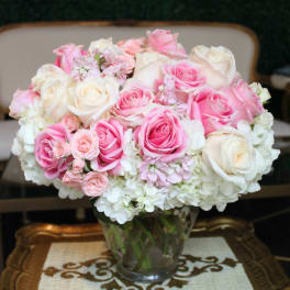 Pink and white roses arranged in a clear glass vase