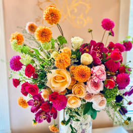 Colorful bouquet of roses, dahlias, and orchids in a floral vase