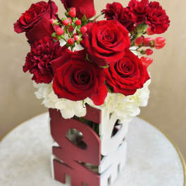 Red roses and carnations arranged in a decorative box