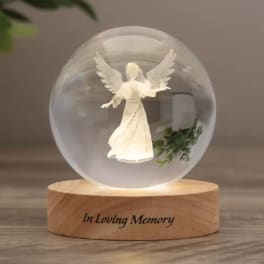 Glass angel memorial ornament on a wooden base