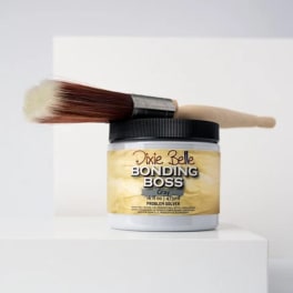 Hair product jar with two makeup brushes on top