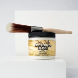 Jar of hair bonding product with a brush resting on top