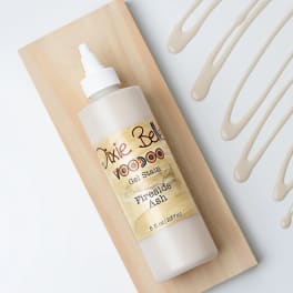 Bottle of Dixie Belle gel stain on a wooden board with paint swatches