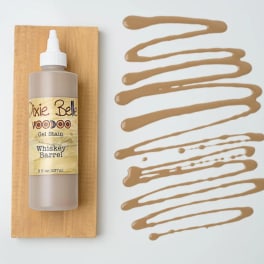 Bottle of Dixie Belle gel stain on a wood board with tan swatches beside it
