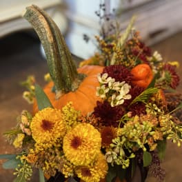 Pumpkin centerpiece with yellow and burgundy flowers