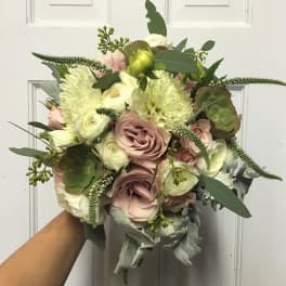 Handheld bouquet of blush and white flowers with greenery