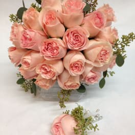 Bouquet of pale pink roses with greenery in a clear vase