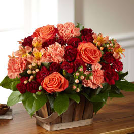 Basket arrangement of orange roses and red carnations