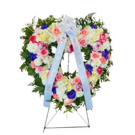 Heart-shaped floral wreath on a standing easel with a blue ribbon