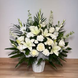 White roses and lilies arranged in a white vase