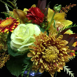 Mixed bouquet with chrysanthemums, lilies, and carnations in a glass vase