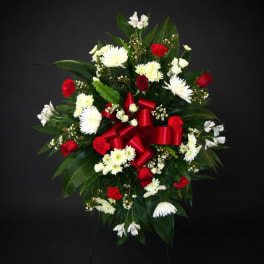 Red and white floral standing spray with a red ribbon bow