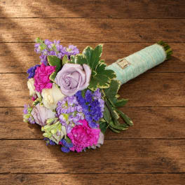 Wedding bouquet with lavender, pink, and white flowers wrapped in pale blue ribbon