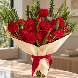 Red flower bouquet wrapped in beige paper with a red ribbon