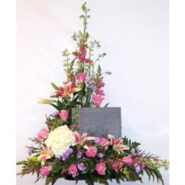 Tall floral spray with pink and white blooms around a gray plaque
