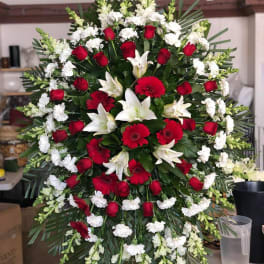 Large red and white funeral spray with roses, lilies, and gerbera daisies